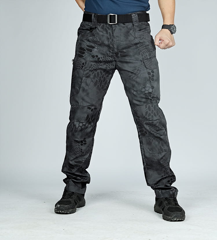 Ix7 men’s tactical cargo pants in black with a dark gray snake-scale camouflage pattern and multiple cargo pockets designed for army training use.