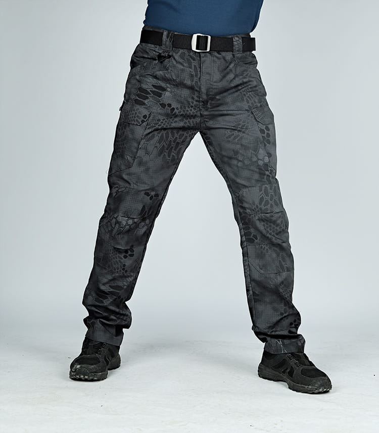 Ix7 men’s tactical cargo pants in black with a subtle dark gray snake-scale camouflage pattern and multiple cargo pockets designed for army training use.