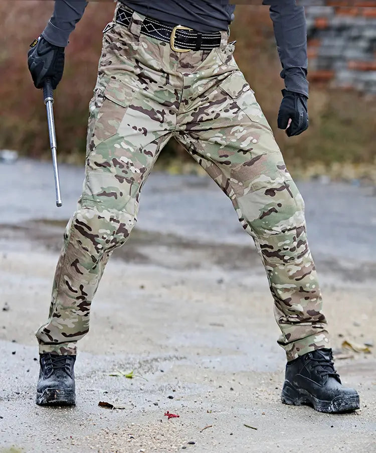 Ix7 men’s tactical cargo pants feature a multi-tone green brown and beige camouflage pattern designed for army training and outdoor use.