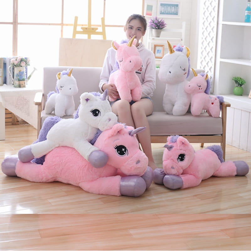 pink and white plush unicorns with purple accents and golden horns made of soft fabric with embroidered eyes in a unicorn plush toy soft pink and purple stuffed animal collection.