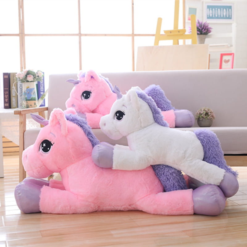 Pink plush unicorn stuffed animal with purple mane and tail, white body accents, and large black eyes, designed as a soft and cuddly toy.