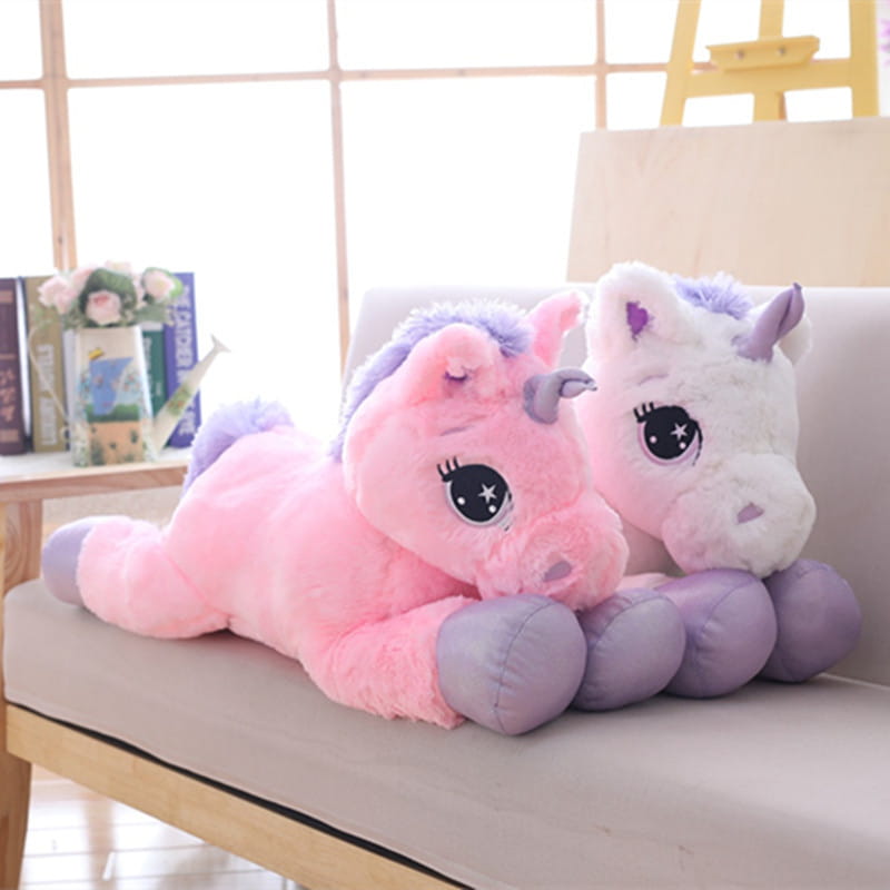 Unicorn plush toy soft pink and purple stuffed animal with pink and white fluffy texture and oversized starry purple eyes.