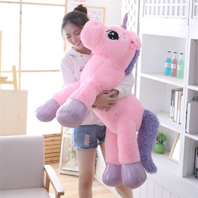 Pink plush unicorn toy featuring a soft pink body with purple mane tail and hooves suitable as a stuffed animal.