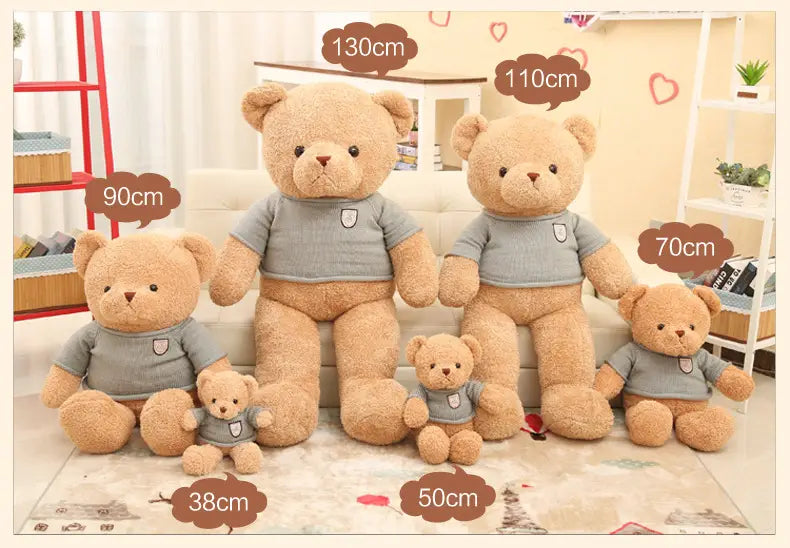 Una familia de cinco peluches de osos de peluche con camisas grises a juego de manga corta y un pequeño emblema blanco en el pecho, incluido en un producto de oso de peluche con suéter de punto de 55 cm.