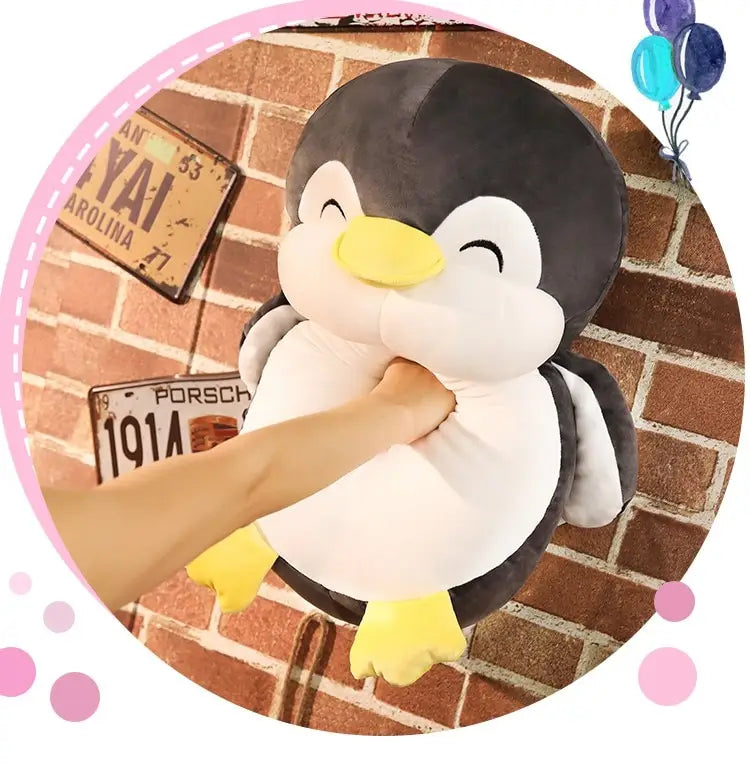 Ein Plüsch-Pinguin-Kuscheltier für Kinder mit weichem schwarzem-weißem Körper, gelbem Schnabel und gelben Füßen sowie geschlossenen Augen.
