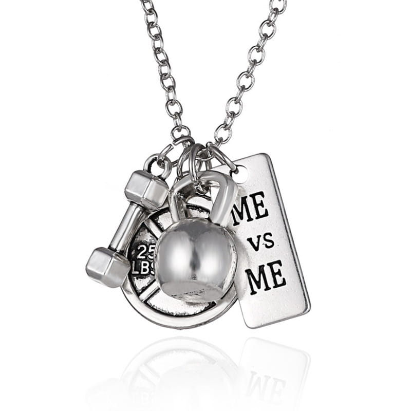 Silver-toned inspirational fitness pendant necklace featuring dumbbell kettlebell and rectangular me vs me tag charm for gym motivation.