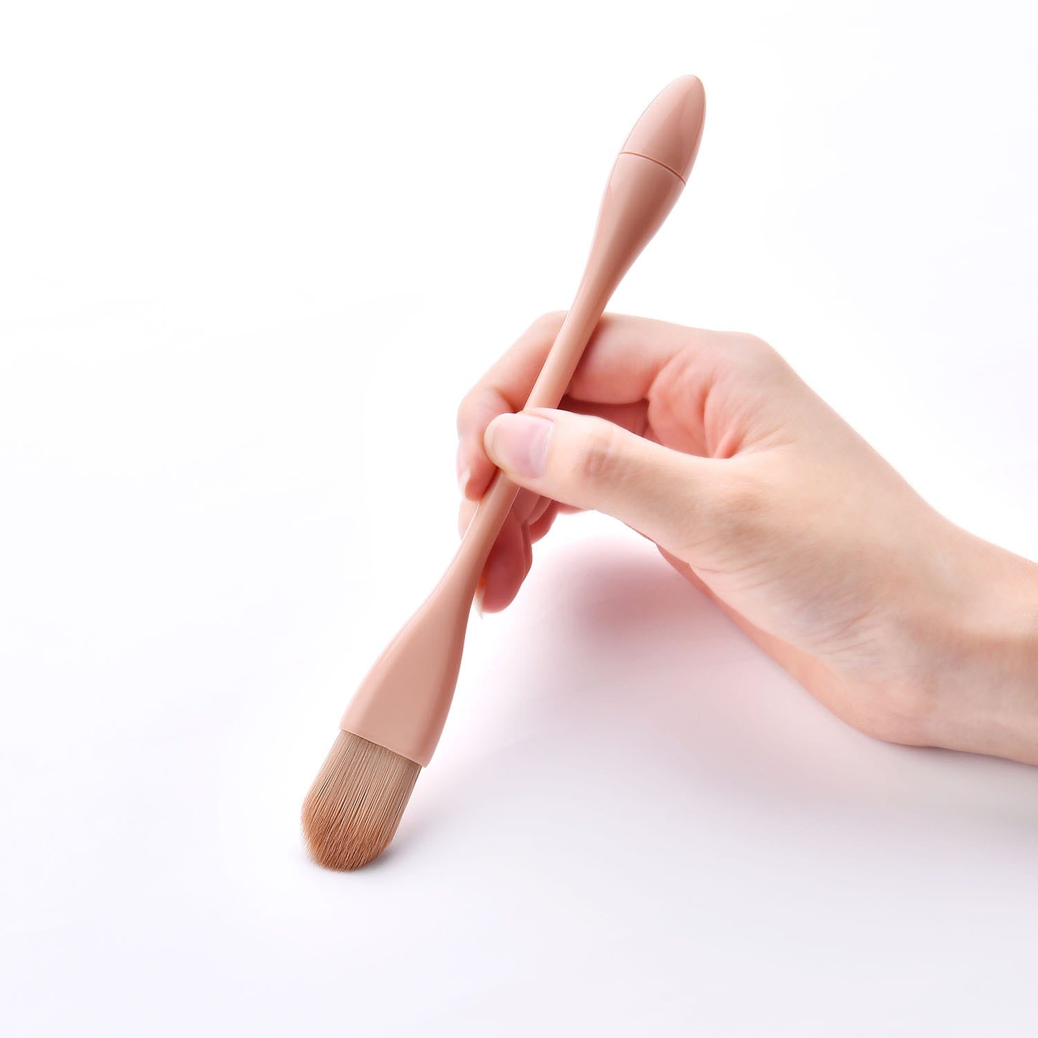 A sleek blush-pink makeup brush with a silicone handle and soft tapered nylon bristles from the pink makeup brush set 10pc professional nylon tools.