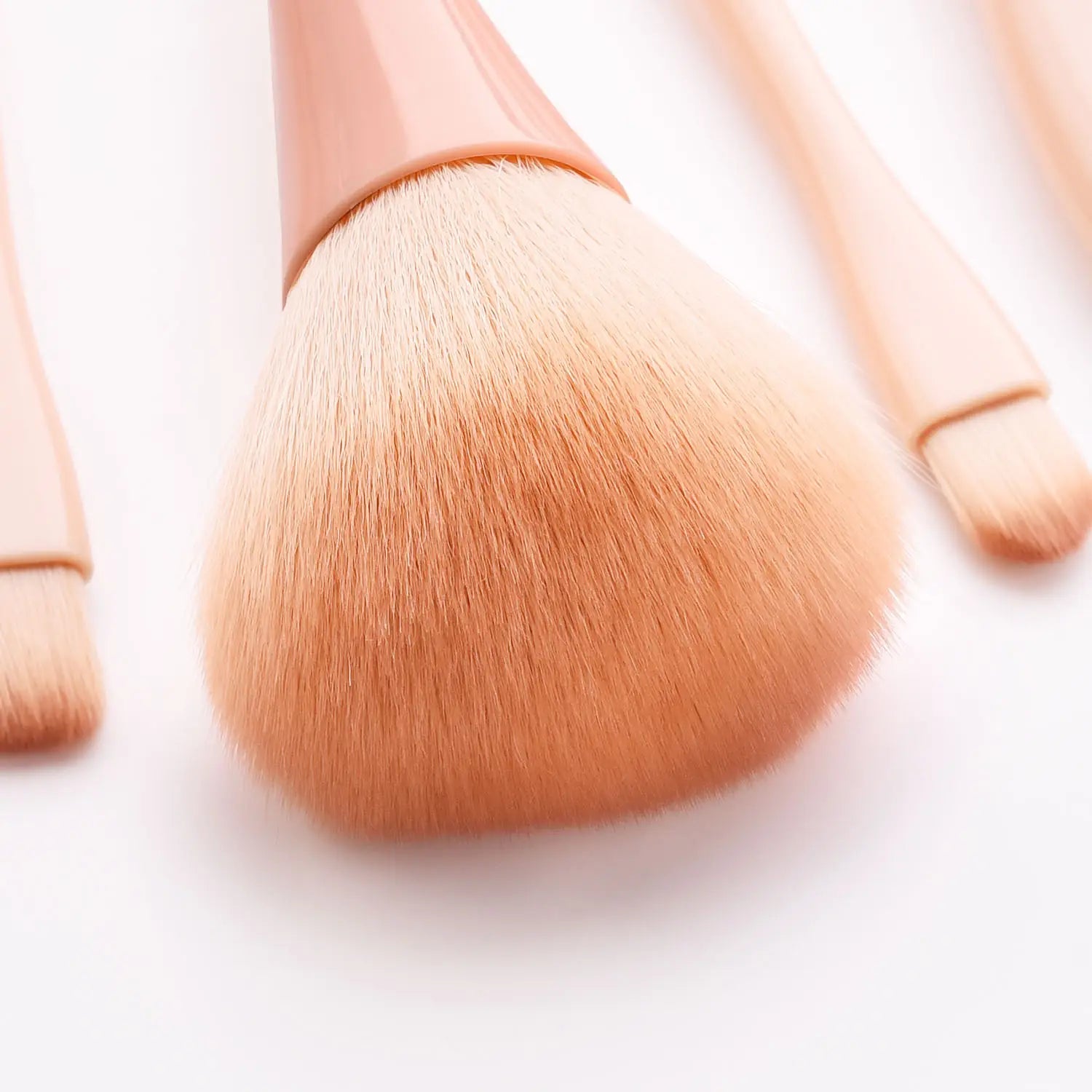Blush brush with soft peach-colored nylon bristles and a matching matte pink handle from the pink makeup brush set 10pc professional nylon tools.