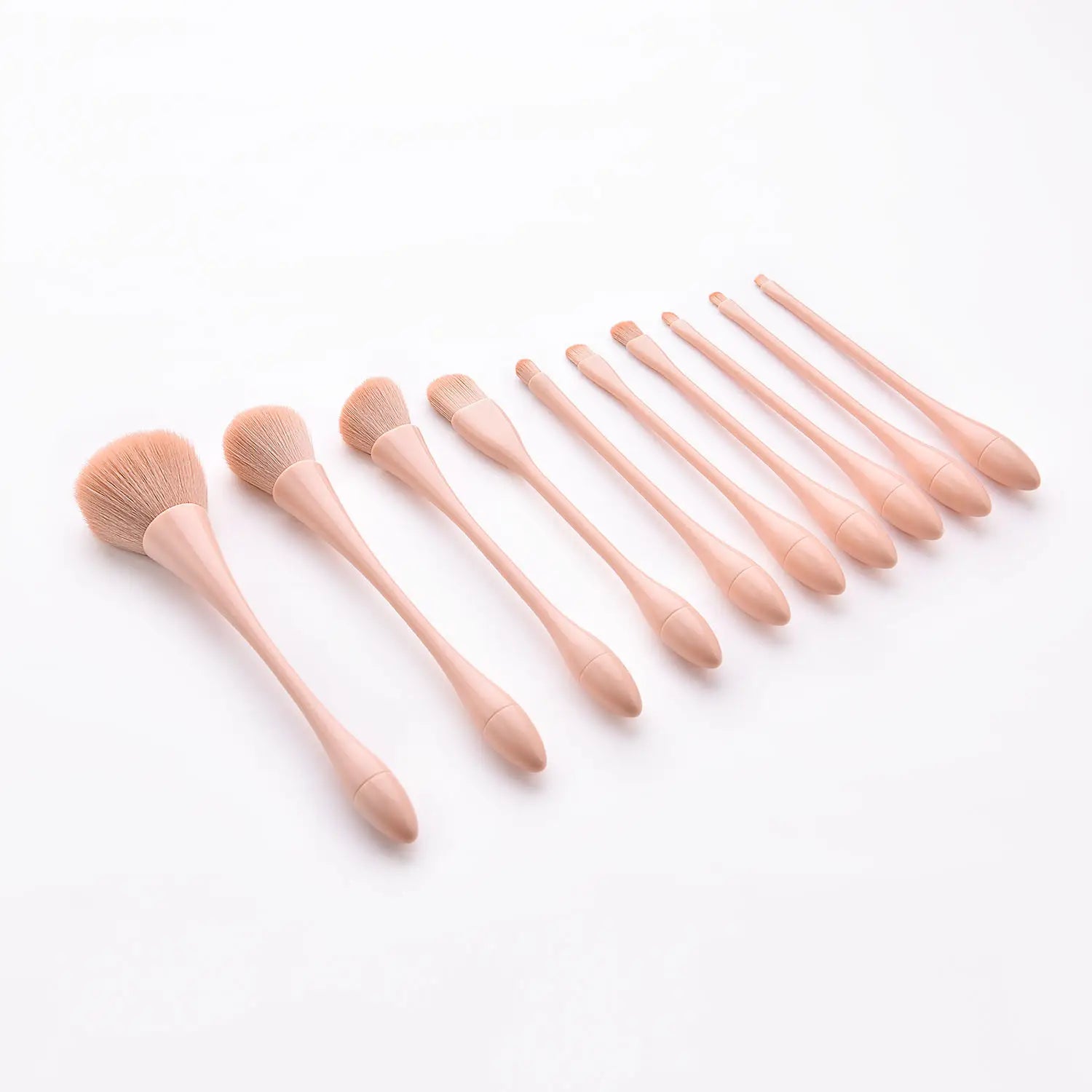 Set of ten professional nylon blush and foundation makeup brushes with soft peach-colored handles and natural bristles from the pink makeup brush set 10pc.