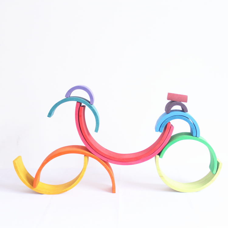 Rainbow wooden stacking arch bridge 12 piece puzzle toy featuring rainbow-colored wooden arches arranged in a bicycle shape.