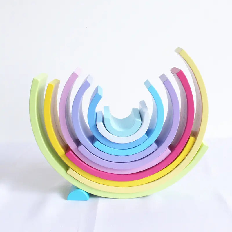 A colorful wooden rainbow stacking arch bridge puzzle toy featuring 12 smooth rounded pastel arcs in green yellow pink purple and blue.