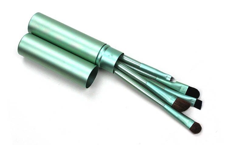 Travel eye makeup brush set with five teal metallic brushes with black and brown bristles housed in a matching cylindrical portable case.