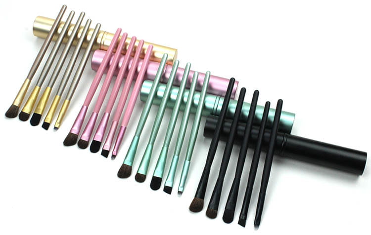 a travel eye makeup brush set with 24 soft bristle brushes featuring metallic handles in gold pink mint green and black designed for various cosmetic applications.
