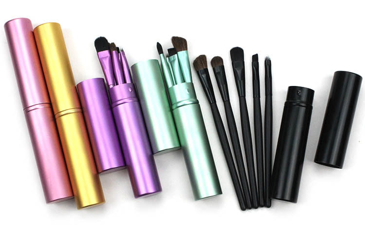 set of colorful metallic travel eye makeup brushes in pastel and black finishes neatly arranged with matching portable cylindrical cases