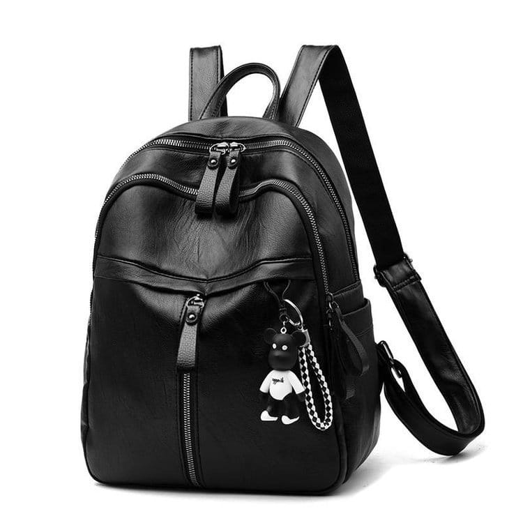 Black leather school backpack with multiple zippers and a small black and white bear charm hanging from the front.