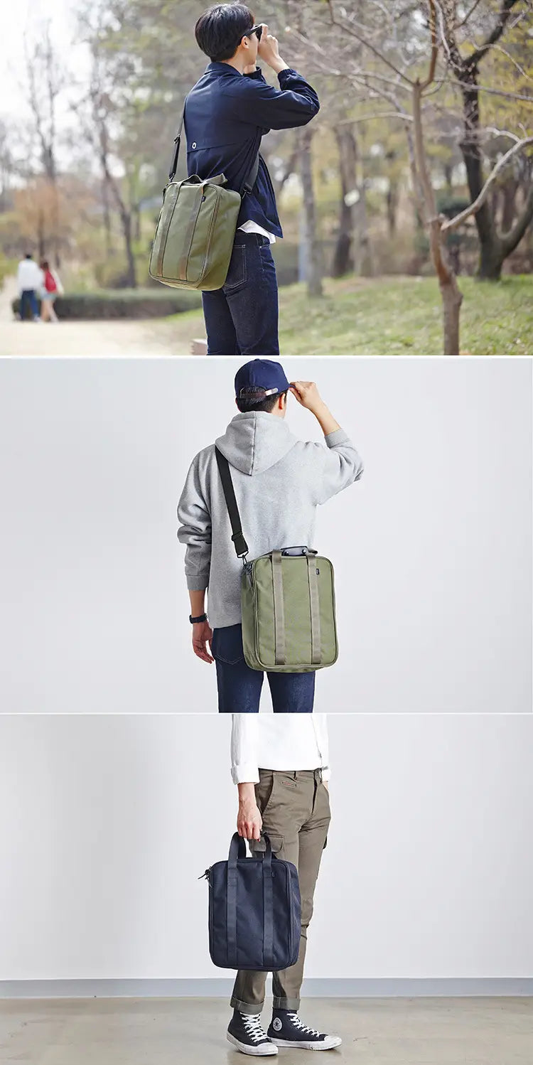Olive green cotton canvas travel bag with black shoulder strap and top handle designed as a storage cube organizer.
