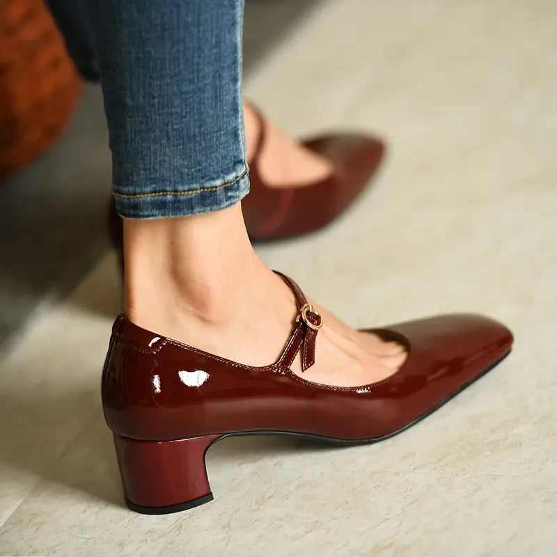 Bordeauxrote Lackleder-Mary-Jane-Schuhe mit Blockabsatz, eckiger Schuhspitze und vergoldeter Schnalle.