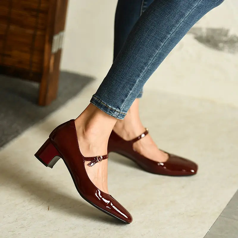 Bordeauxrote Lackleder-Mary-Jane-Schuhe mit Blockabsatz, eckiger Schuhspitze und niedrigem, robustem Absatz, von der Rückseite dargestellt.