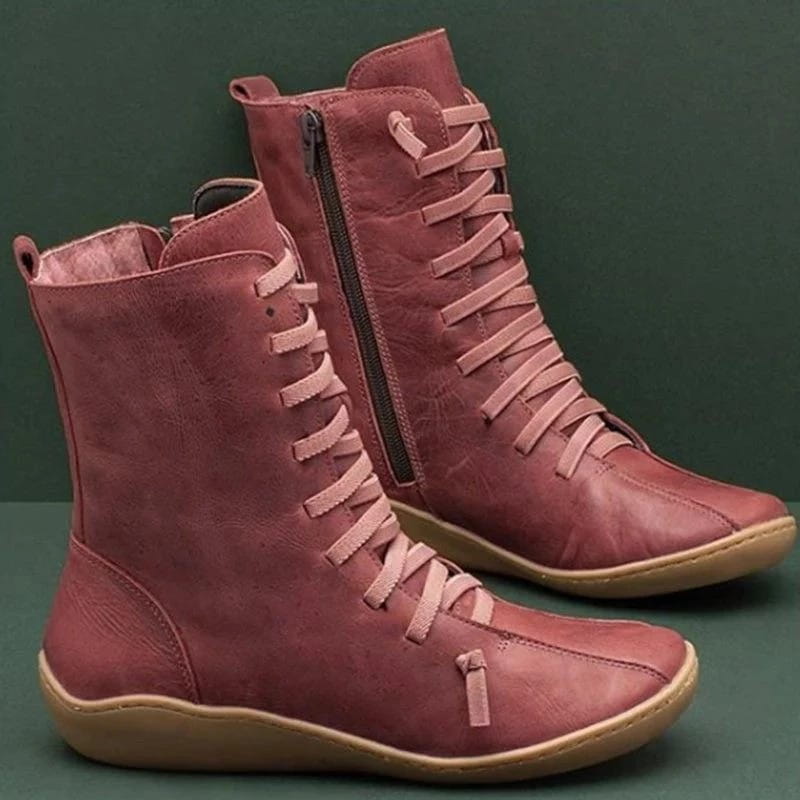paire de bottines Martin en daim rosé poussiéreux, à lacets, avec fermeture éclair sur le côté intérieur et semelles en caoutchouc de couleur claire.