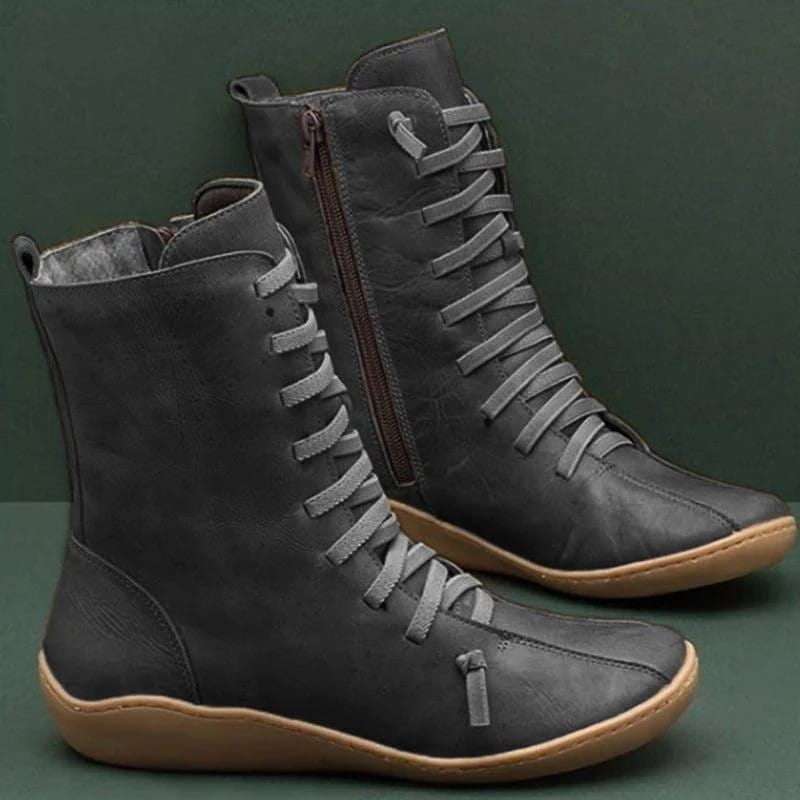 bottines Martin en daim gris foncé, à lacets, avec semelle en caoutchouc ambré et fermeture éclair sur le côté intérieur.