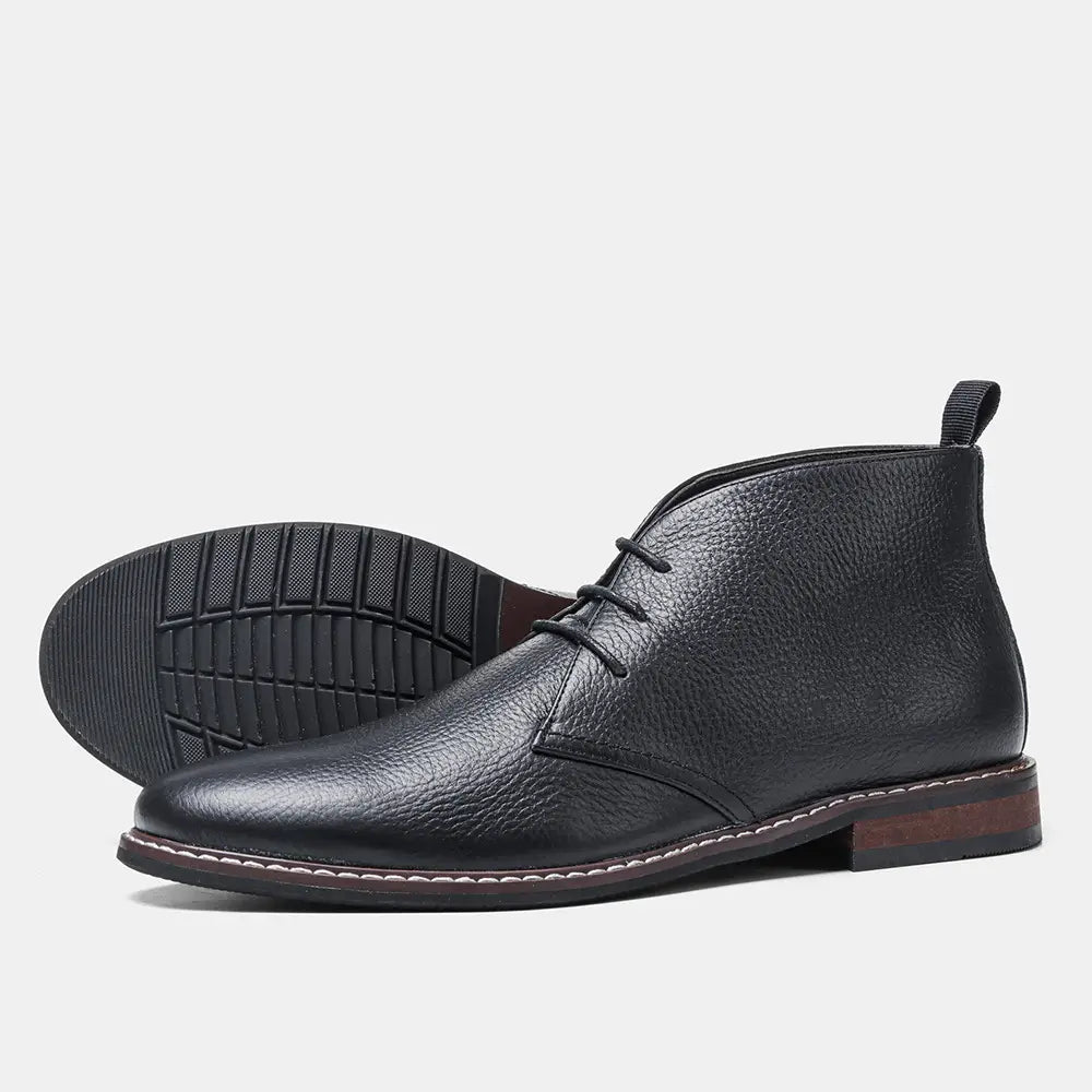 Men’s lychee pattern cowhide Chelsea Martin boots in black leather with textured surface and contrasting white stitching along the sole.