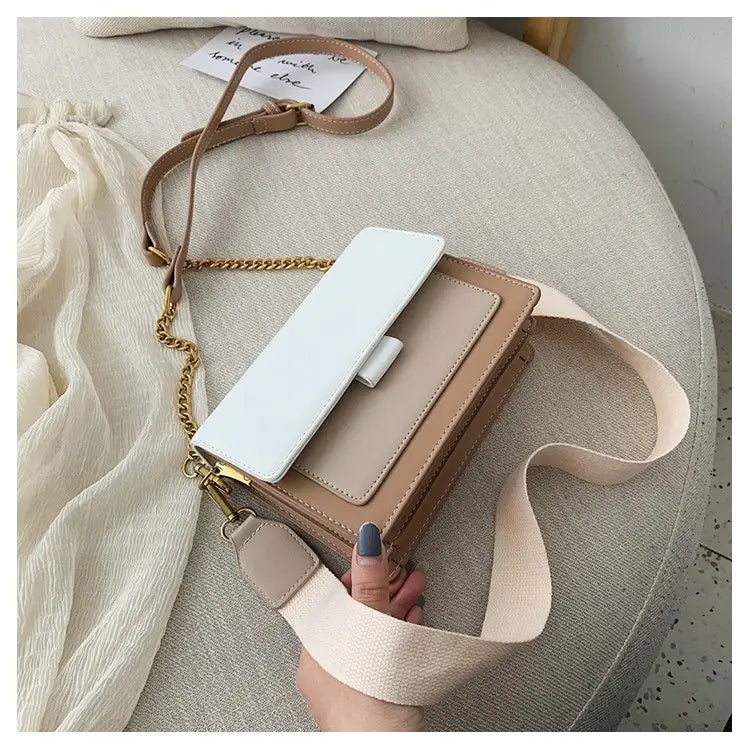 Beige and white square crossbody bag in two tone faux leather with gold chain and dual straps for versatile carrying options.