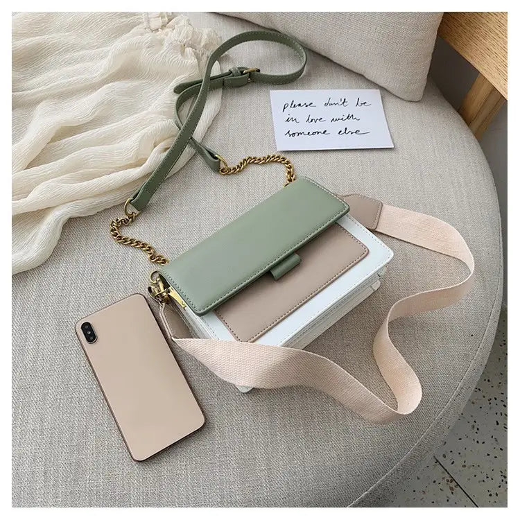 Pastel green and beige square crossbody bag made of two-tone faux leather with a gold chain strap.