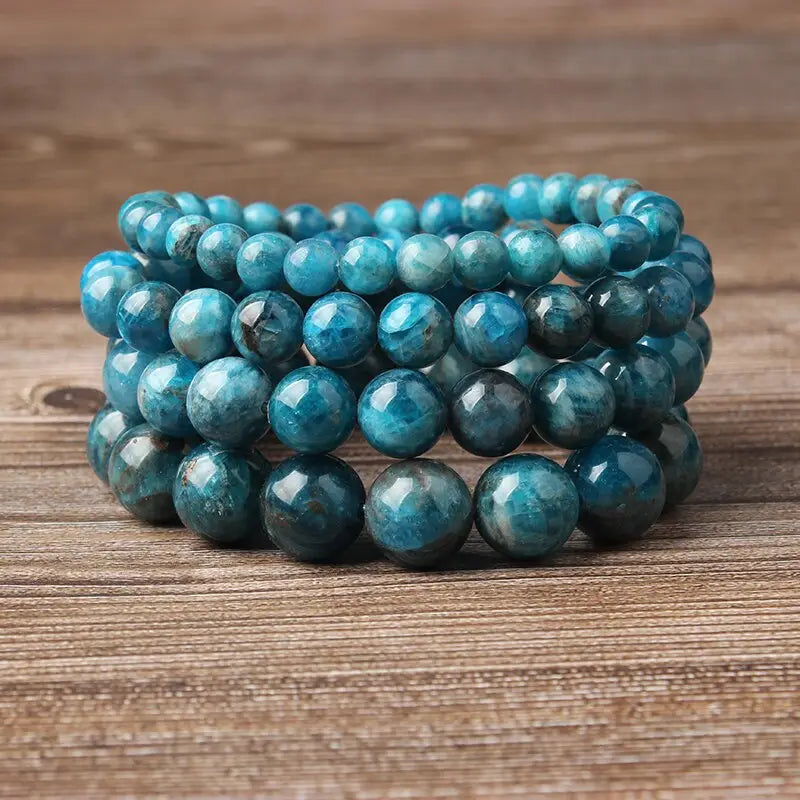 Stacked turquoise-blue aventurine bead bracelets feature polished faceted stones in a natural blue apatite polished stone elastic bead bracelet design.