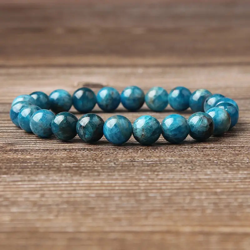 Natural blue apatite polished stone elastic bead bracelet featuring smooth round turquoise-blue beads with natural mineral patterns.
