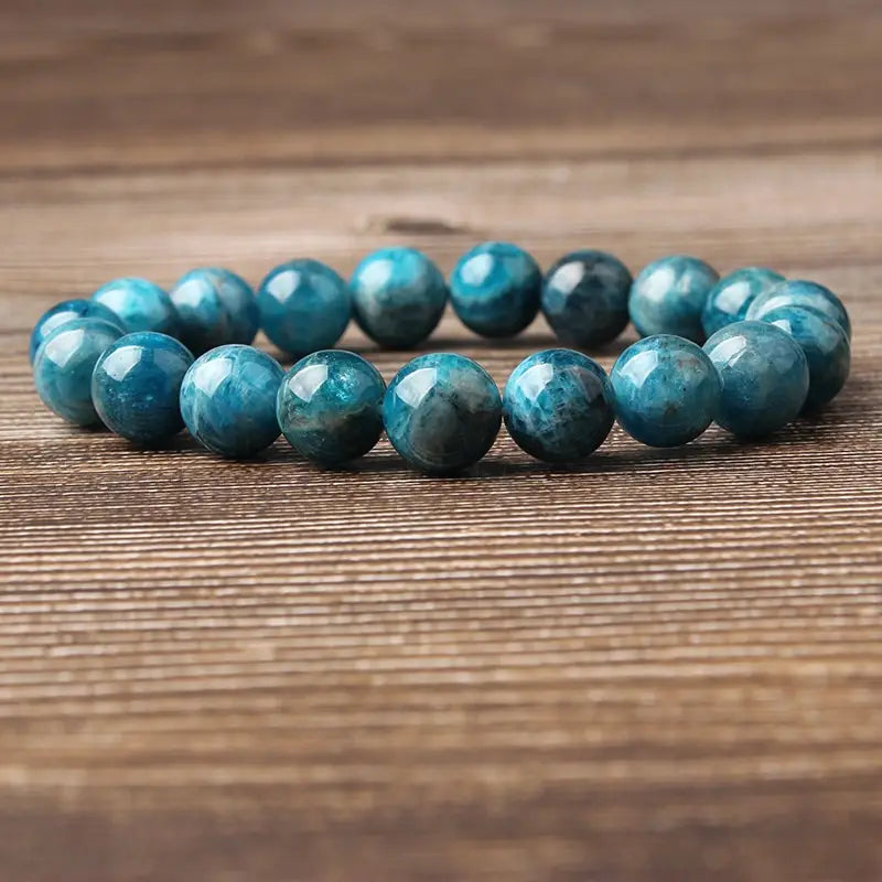 Natural blue apatite polished stone elastic bead bracelet featuring smooth round turquoise blue beads with natural mineral patterns.
