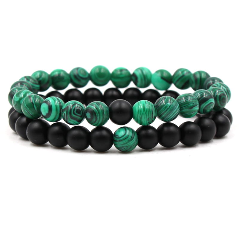 Two stacked beaded bracelets featuring alternating green malachite and matte black elastic spherical beads.