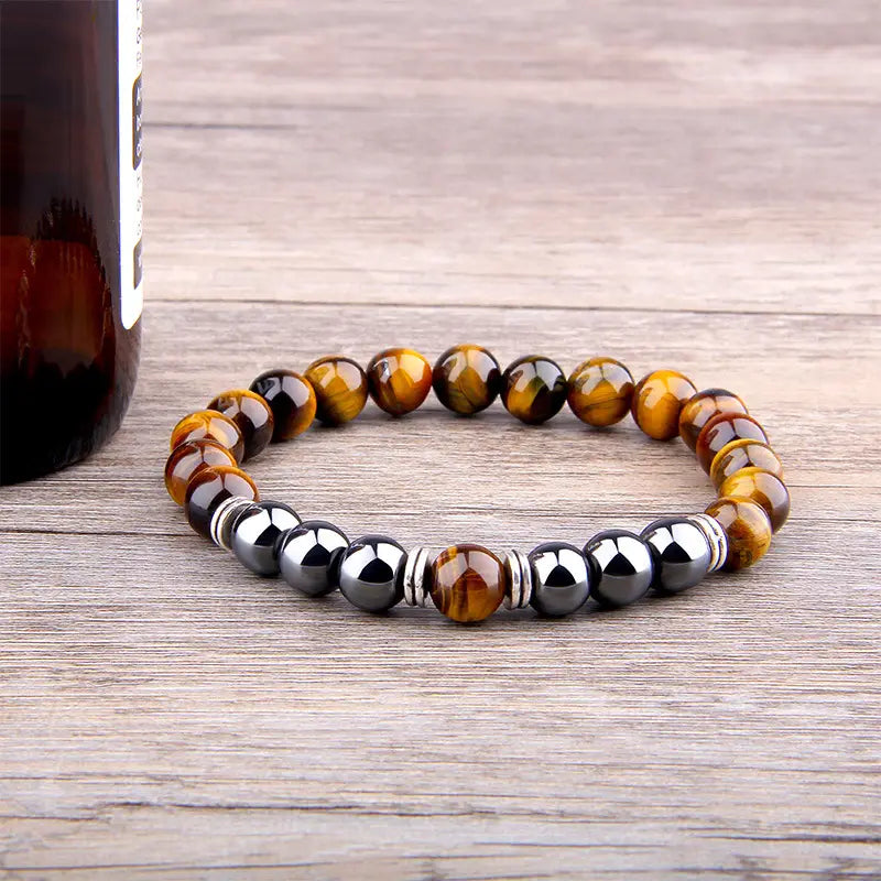 A stylish tiger eye and black magnetic bead elastic bracelet with silver-toned spacers featuring a polished earthy design.