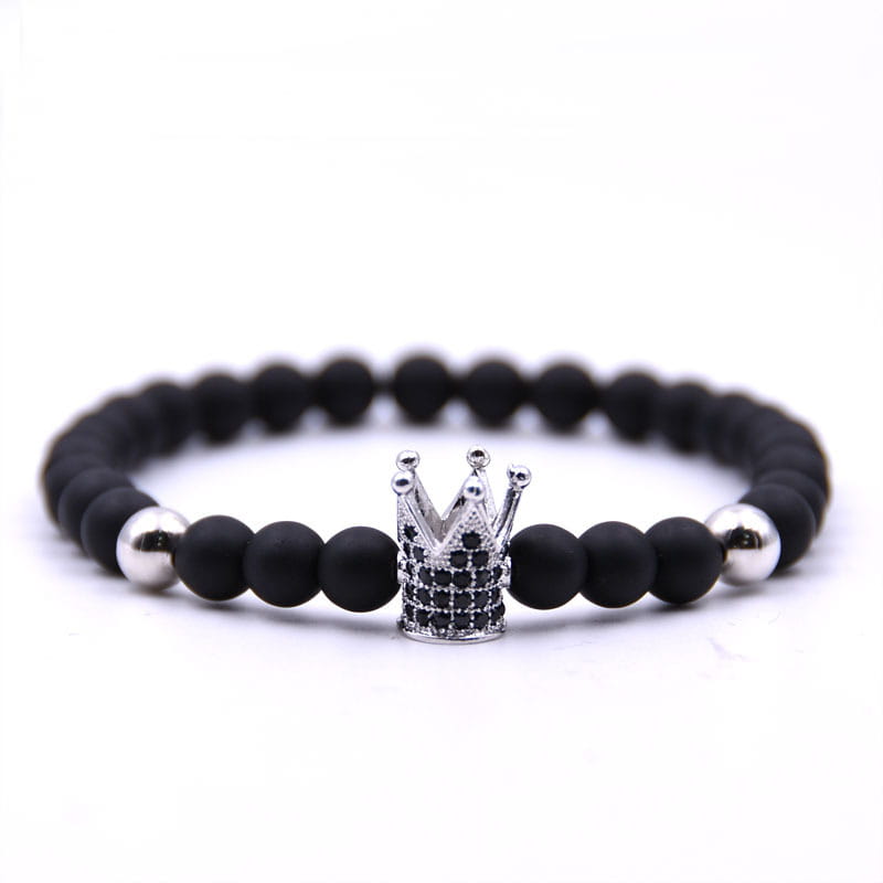 Luxury zircon crown matte black beaded bracelet featuring a black beaded band with a silver crown charm adorned with black stones and accented by two polished silver beads.