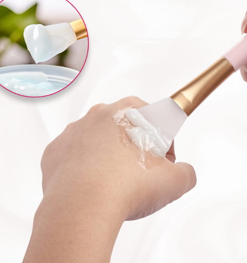 A soft white silicone facial mask brush with a gold-colored handle from the fan makeup brush set iridescent gradient handle 3pc.