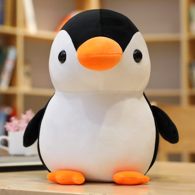 Niedliches, weich gepolstertes Pinguin-Plüschspielzeug in Schwarz-Weiß mit einem orangefarbenen Schnabel und Füßen, entworfen als Kuscheltier für Kinder und Jugendliche.