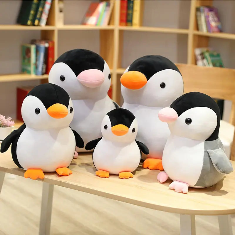 Niedliche weiche Plüsch-Kuscheltiere in Pinguin-Form in Schwarz, Weiß und Orange mit pinken Schnäbeln und Füßen, entworfen für Kinder und Jugendliche.