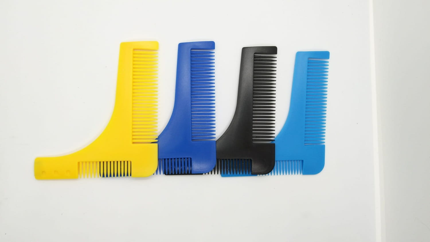 Vierer-Set aus farbenfrohen Kunststoff-Schablonen zur Bartformung mit integrierten Konturkämmen in Gelb, Blau, Schwarz und Hellblau für präzises Pflegen.