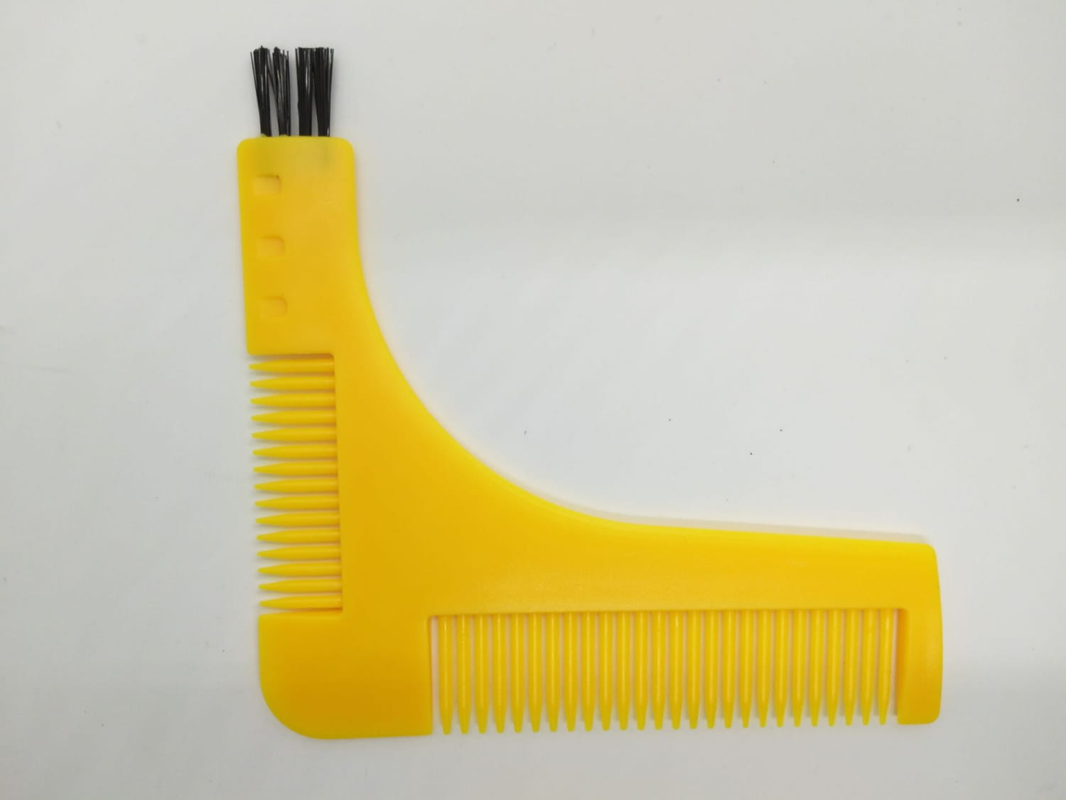 Schablone zur Bartformung mit einem gelben Kunststoffkamm mit schwarzen Borsten und geschwungenem Design für präzises Pflegen.