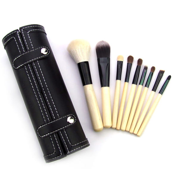 black leather brush case with white stitching and silver rivets holding a 10 piece makeup brush set with wooden handles and black ferrules for makeup application