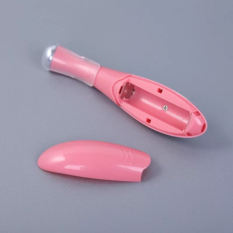 Pink plastic eye massager eyelash curler with clear protective cap and removable cover designed for wrinkle and dark circle removal.