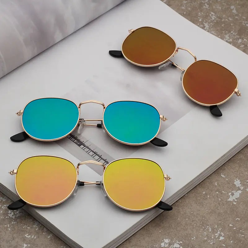 Set of three round rose gold aviator sunglasses with metallic gradient mirrored lenses in blue orange and brown hues.