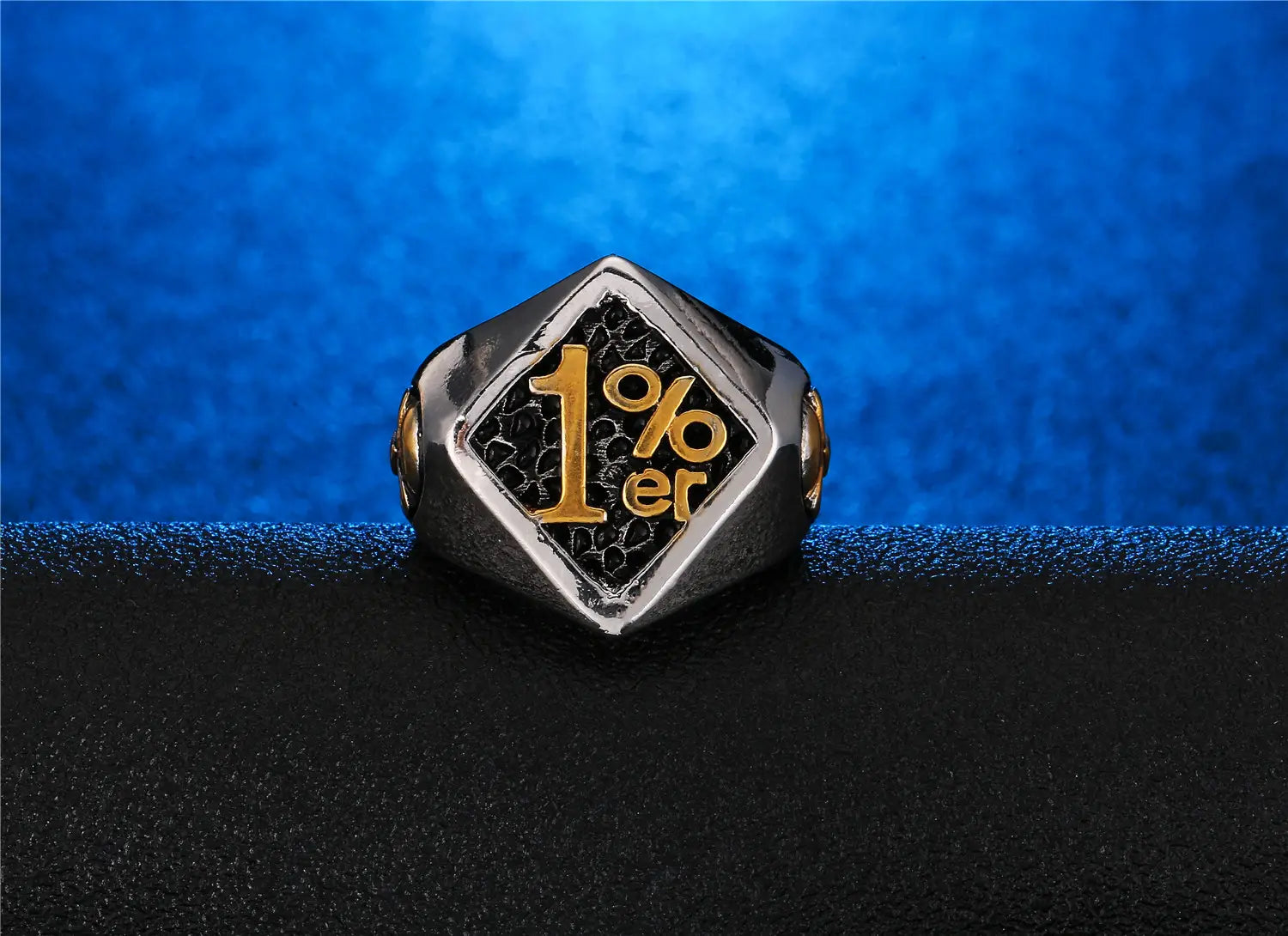 Un elegante anillo de sello de biker 1%er hexagonal de acero inoxidable con una banda de acabado plateado e incrustación negra, con letras en color dorado.