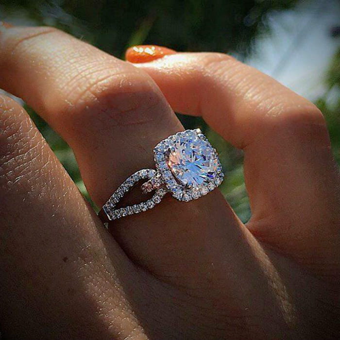 A sparkling square-cut diamond halo engagement ring set in a sleek silver band.