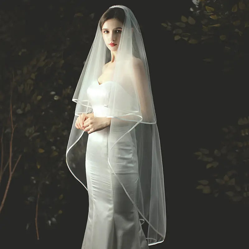 Double layer white tulle short veil with hair comb featuring a delicate sheer fabric with subtle sheen and softly flowing edges.