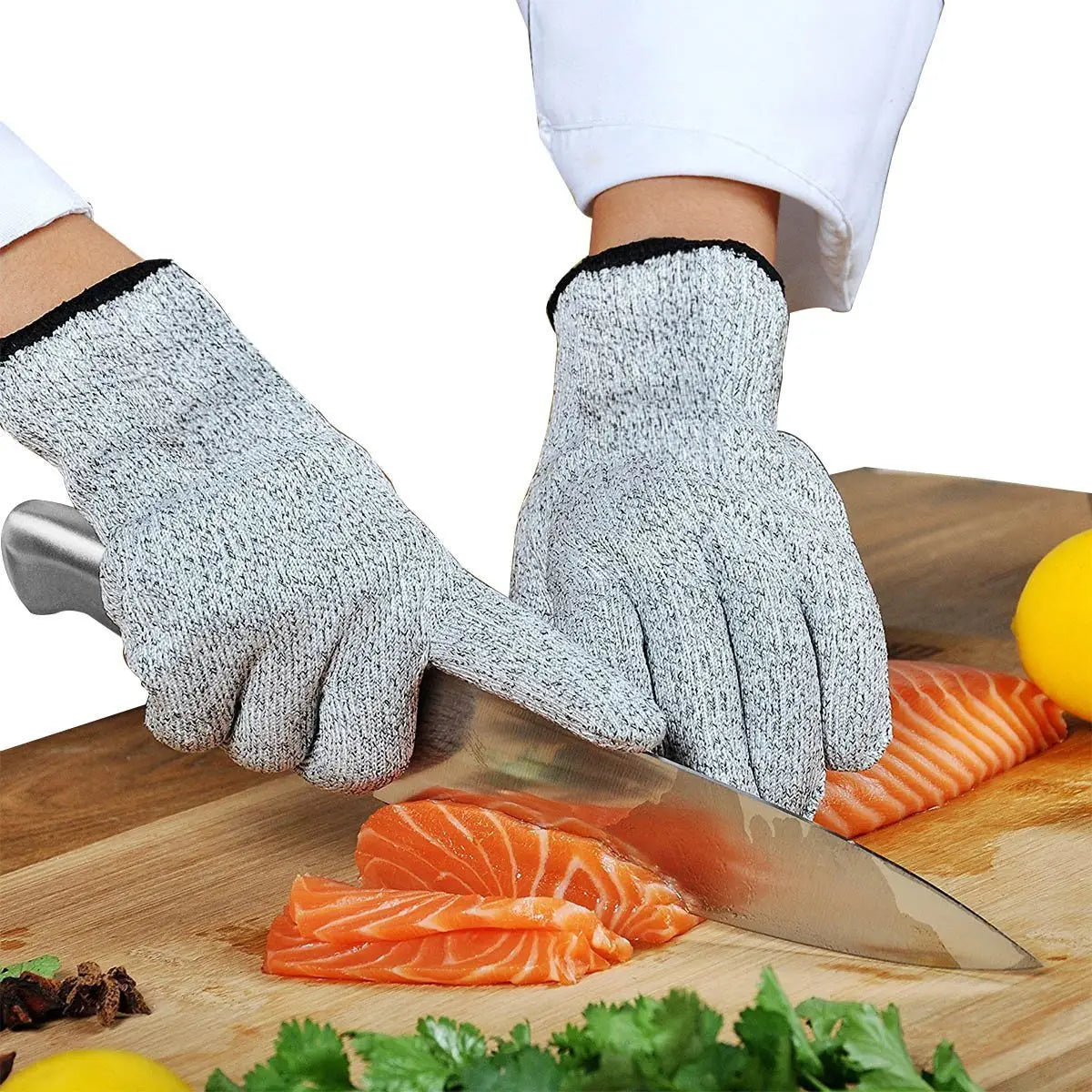 gray textured cut resistant hppe safety work gloves with black trim worn by a chef slicing salmon on a wooden cutting board