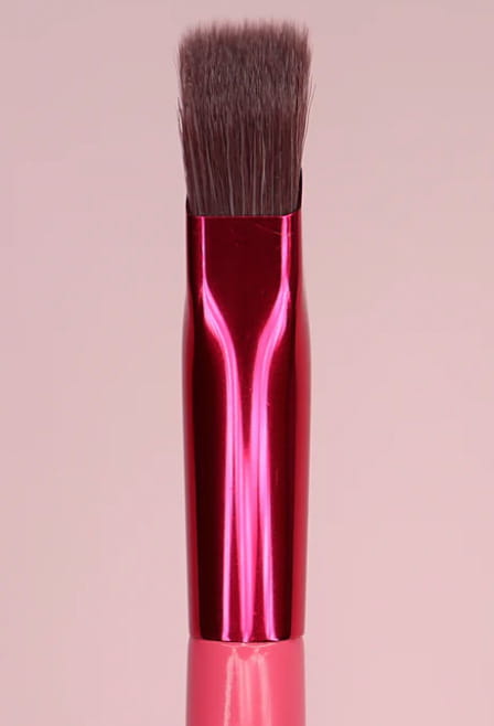 A vibrant pink metallic eyebrow brush with dense dark brown bristles and a pink angled applicator for precise gel application.