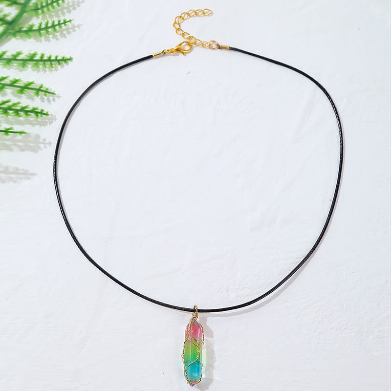A vibrant rainbow-colored geometric crystal wire wrapped pendant necklace hangs from a black cord with a gold-toned clasp.