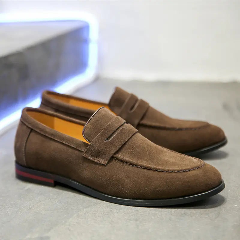 Mocassins penny en daim pour hommes, en marron, avec un design classique et une doublure orange contrastante pour des chaussures décontractées en cuir à enfiler.