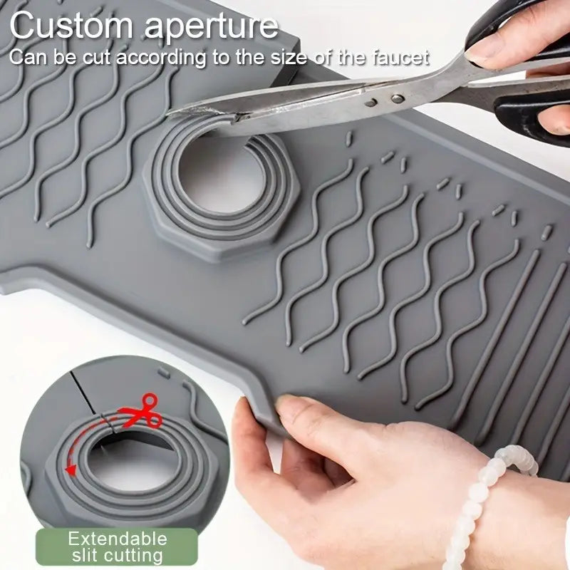 Gray silicone self draining kitchen sink faucet mat with customizable cutout and extendable slit cutting feature for precise faucet fit.