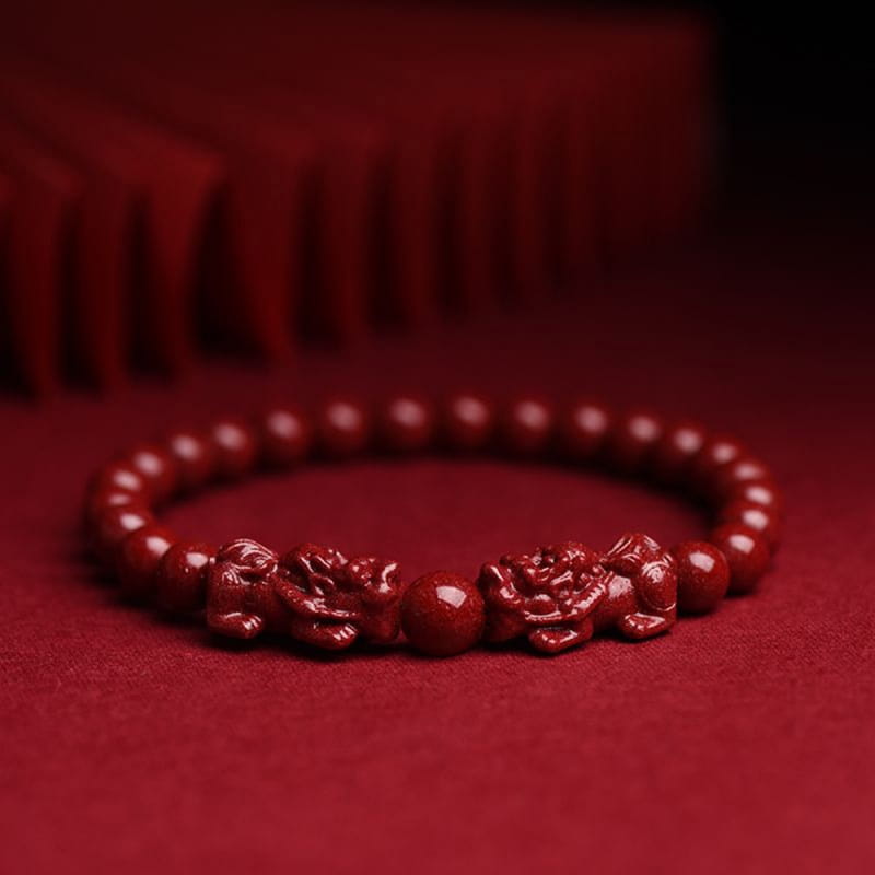 Hand carved purple gold cinnabar double pixiu bracelet featuring a red jade bracelet with intricately carved dragon motifs between smooth round beads.